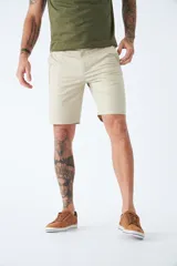 Bermuda tipo chino de gabardina, con bolsillos laterales y traseros, cierre de cremallera y botón, y pasacintos en la cintura. Presenta un diseño clásico con logo bordado.