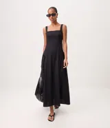 Vestido midi negro confeccionado en tricolina de algodón, con escote cuadrado, breteles anchos y corte con frunces laterales en la cintura. Presenta falda amplia y diseño de la marca Marfinno.