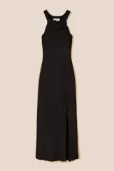 Vestido largo de punto acanalado en color negro, con diseño de sisa americana y cuello redondo decorado con una flor de crochet hecha a mano. Presenta un ribete de trenza de crochet y una abertura lateral en la parte inferior.