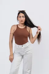 Body de algodón suave y elastizado de color blanco, con cuello a la base tipo halter y diseño cavado de tiro alto.