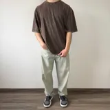 Remera oversize gris con efecto lavado, de manga corta y cuello redondo. Presenta un gran diseño bordado en la espalda con el contorno de una estrella y letras superpuestas.