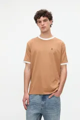 Remera de manga corta color tostado con cuello redondo y ribetes en los puños de color blanco. Presenta un pequeño bordado en el pecho y detalles en los hombros.