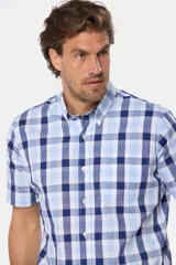 Camisa de hombre a cuadros en tonos azul, blanco y rosa, de manga corta y corte clásico. Confeccionada en algodón y con botones personalizados.