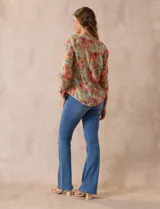 Blusa estampada de Zac & Rachel con cuello a la base, escote en V y botones. Tiene un bolsillo aplicado en la parte delantera, mangas largas regulables con presilla y botón, y terminación anudada opcional.