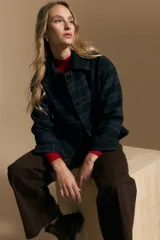 Tapado corto de lana con diseño a cuadros en tonos azul y negro, cuello camisero y cierre frontal con botones.