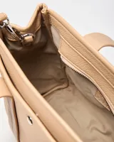 Cartera mediana XL color beige de símil cuero con textura granulada, doble asa de mano, correa ajustable y desmontable, y detalle de llavero en forma de corazón.