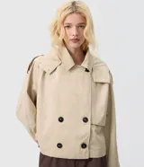 Trench coat cropped beige con capucha, cierre cruzado con botones y mangas largas.