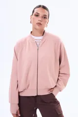 Campera de felpa tipo bomber, color rosado, con cierre frontal completo, cuello redondo y mangas largas con puños ajustados.