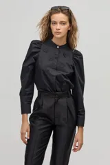 Camisa de algodón a rayas verticales blancas y celestes, con cuello mao y cierre frontal de botones. Presenta mangas largas con hombros fruncidos y aplicaciones bordadas en forma de corazones.