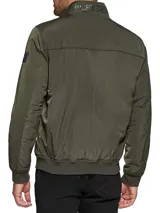Campera bomber verde militar de poliéster, con cuello mao, cierre frontal con cremallera, dos bolsillos laterales con cremallera, puños y ruedo elásticos. Logo de Tommy Hilfiger bordado en el pecho.