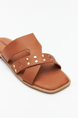 Sandalias bajas negras de símil cuero, con tiras asimétricas y apliques de tachas.