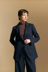 Blazer de corte sastrero con solapas clásicas y estructura definida. Presenta un diseño versátil con silueta ligeramente oversized, ideal para un estilo sofisticado y atemporal.