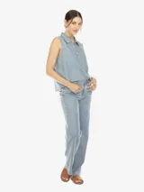 Musculosa de denim celeste, con cuello polo, escote en V con botones, sin mangas, de fit amplio y terminación desflecada.