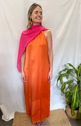 Vestido largo naranja con escote halter y chal fucsia.