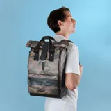 Mochila Cabaia modelo Explorer Puebla con estampado de camuflaje en tonos verde, marrón y negro. Cuenta con tapa enrollable, revestimiento impermeable, cremalleras AquaGuard, espumas traseras, bolsillo exterior para botella de agua, rayas reflectantes, compartimento principal amplio, bolsillo para ordenador de hasta 16 pulgadas, hebilla de bloqueo magnético Fidlock, correa para el pecho y sistema MOLLE para bolsas intercambiables.