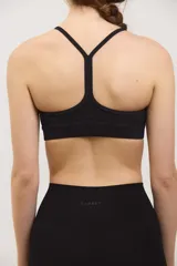 Top deportivo negro de compresión media, con escote redondo clásico, tiras finas cruzadas en la espalda y tazas intercambiables.