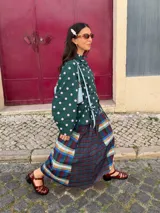 Camisa negra de popelina con diseño de flor azul estampada en el frente. Presenta cuello clásico, mangas abullonadas y detalle de cordones laterales tipo corset para ajustar la silueta.