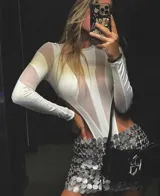 Body blanco de mangas largas con transparencias y recortes geométricos.