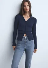 Pantalón de jean estilo flare con tiro medio, diseño crop y bajo deshilachado. Cuenta con cinco bolsillos, cierre de cremallera y botón, y trabillas para cinturón.