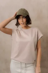 Sweater de punto color blanco, de corte relajado, con cuello redondo, manga corta japonesa de hombro caído y pretina ancha en la cintura.