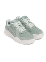 Championes Under Armour modelo Court Anatomix, color verde menta con detalles en blanco. Presentan una parte superior que combina gamuza y materiales sintéticos, con una entresuela de EVA acolchada y suela de goma gruesa.