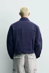 Cazadora relaxed fit de algodón en color azul marino con efecto lavado, cuello solapa, bolsillos con solapa en el pecho y cierre frontal con botones metálicos.