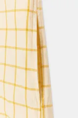 Vestido midi camisero de algodón, color amarillo con estampado a cuadros. Cuenta con cuello solapa, escote en V, mangas cortas con puño y bolsillos laterales ocultos en la costura, con diseño evasé.