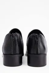 Zapato tipo mocasín de cuero vacuno con textura grabada, diseño de punta fina y taco bajo cuadrado. Cuenta con cierre en la parte posterior del talón.