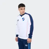 Buzo deportivo Umbro del Club Nacional de Football, color blanco con mangas y detalles en azul marino y rojo. Presenta cuello redondo, el logo de Umbro y el escudo del club bordados en el pecho.