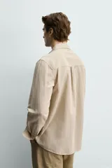 Camisa regular fit de manga larga con diseño a rayas verticales celestes y blancas. Cuenta con cuello abotonado, bolsillo de parche en el pecho y cierre frontal con botones.