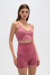 Top color rosa con breteles finos, corte al cuerpo, con elástico en la base y escote profundo.