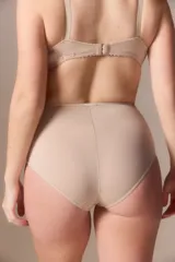 Bombacha tipo vedetina de tiro alto, confeccionada en tricot liso de color beige, con costuras reforzadas en los laterales.