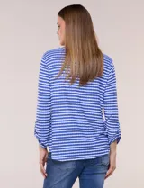 Remera de calce relajado y silueta fluida, con escote en V y mangas tres cuartos con presilla y botón. Diseño de rayas dispuestas en ángulo tipo espiga en el delantero y ruedo redondeado.