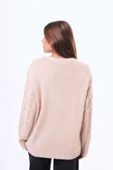 Buzo tejido de punto con diseño de trenzas, color negro, de corte holgado, cuello redondo y mangas largas.