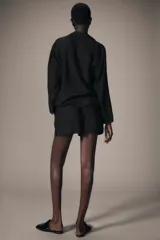 Shorts de tiro medio confeccionados en lino, con cintura elástica y bolsillos laterales ocultos en costura.