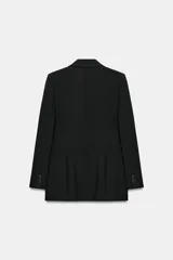 Blazer de corte estructurado con hombreras, cuello de solapa y manga larga. Presenta un diseño cruzado con cierre frontal de botones y bolsillos delanteros con solapa.