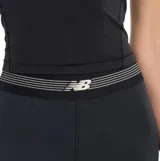 Calza deportiva de tiro alto New Balance, color negro, con banda elástica en la cintura que incluye el logo de la marca. Confeccionada con tecnología NB Sleek de tejido elástico en cuatro direcciones.