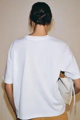 Remera oversize blanca de algodón con cuello redondo, manga corta y estampa con la inscripción 'NEW YORK' en color negro en el frente.