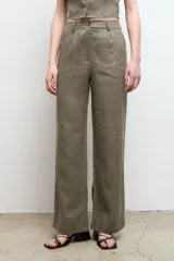 Pantalón de vestir color beige, de corte recto y tiro alto, confeccionado en lino 100% con bolsillos laterales.