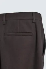 Pantalón de corte recto confeccionado en tejido con lana, color beige. Presenta bolsillos frontales, bolsillos traseros de vivo y cierre frontal con cremallera y botón.