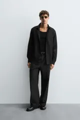 Camisa blanca de manga larga con cuello italiano y cierre frontal de botonadura. Corte regular fit.