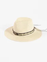 Sombrero de paja color beige con ala ancha y cinta de cuero marrón con apliques metálicos.