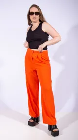 Pantalón sastrero naranja de corte palazzo con pinzas en la cintura y cierre con botón y cremallera.