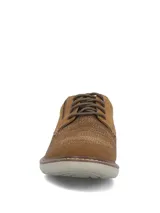 Zapato Hush Puppies modelo Bangu de estilo casual, confeccionado en cuero marrón con paneles de tejido tipo malla en la capellada para mayor ventilación, cordones tono sobre tono y suela de EVA en color gris claro.