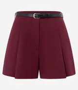 Short de sastrería color bordó, con pliegues delanteros, cierre interno y cinturón fino desmontable.