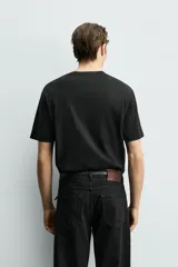 Camiseta de corte cropped fit confeccionada en algodón con acabado mercerizado que aporta suavidad y brillo. Presenta cuello redondo y mangas cortas.