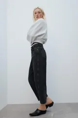 Jeans de tiro medio con diseño de volumen crop y perneras curvas. Presenta cinco bolsillos, cierre frontal con cremallera y botón metálico.