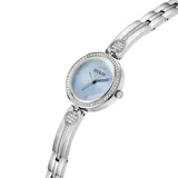 Reloj analógico de estilo joya con caja redonda y malla de acero inoxidable plateado. La esfera es de color celeste con textura sutil, números romanos en las posiciones 6 y 12, y detalles de cristales engastados en el bisel y en los eslabones con forma de corazón.