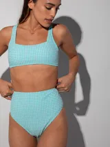 Conjunto de bikini con corpiño estilo top deportivo y bombacha de tiro alto, ambos con estampado a cuadros vichy en tonos celeste y blanco.