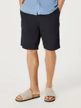 Bermuda de corte recto en color negro, confeccionada en tejido de algodón, con cierre frontal y bolsillos laterales.